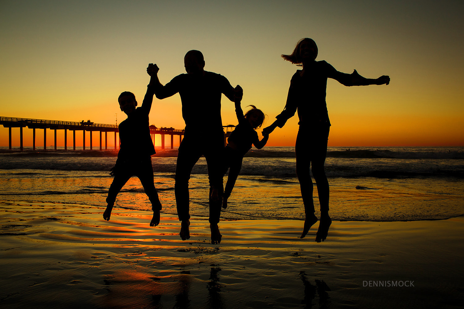 San Diego family playing in the surf and sandcastles at La Jolla scripps pier . Photo by Dennis Mock Photography