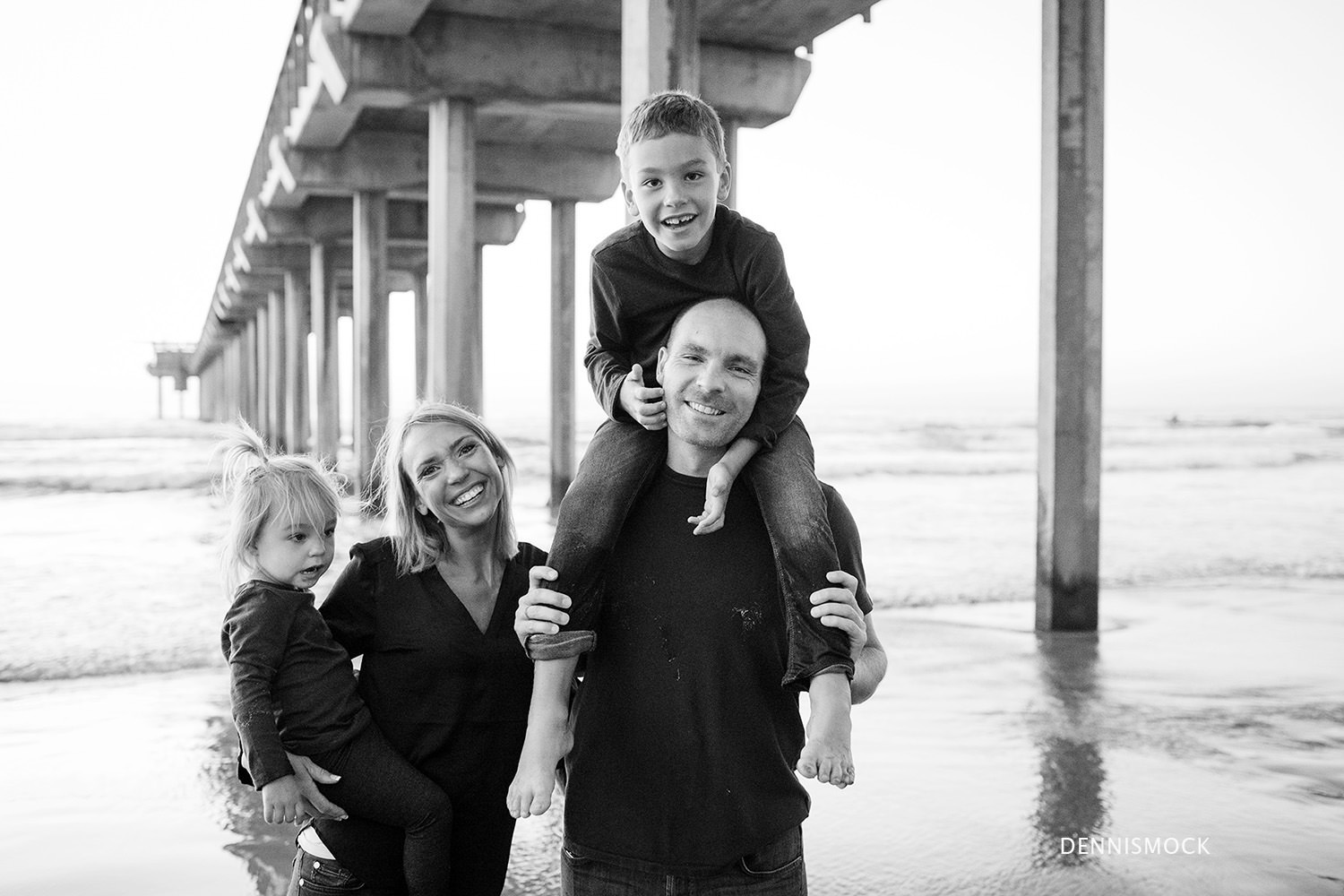 Black and white image of family enjoying time together during a family portrait session in La Jolla